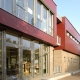 Ein rotes Schulgebäude, schräg fotografiert, mit großen Fenstern